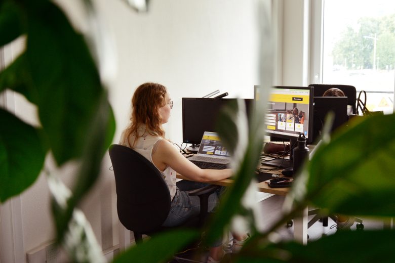 Collaboratrice en réunion qui travaille sur son ordinateur
