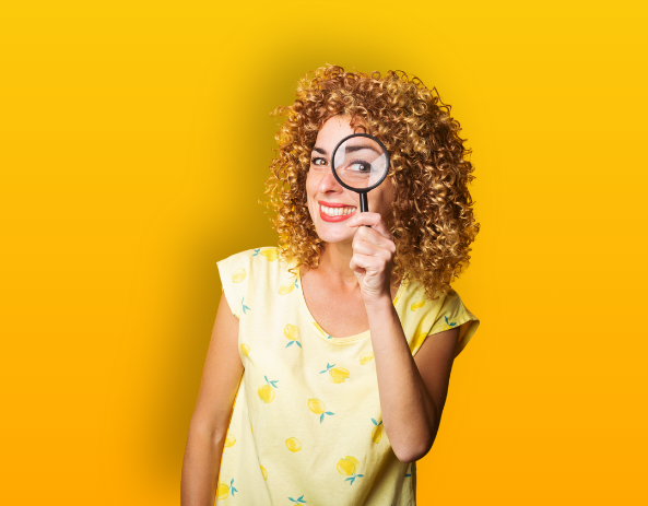 Femme tenant une loupe devant son oeil gauche