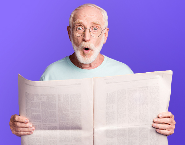 Un vieil homme lisant un journal papier