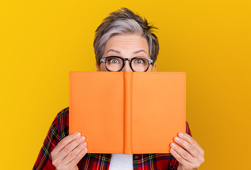 Personne lisant un livre orange.